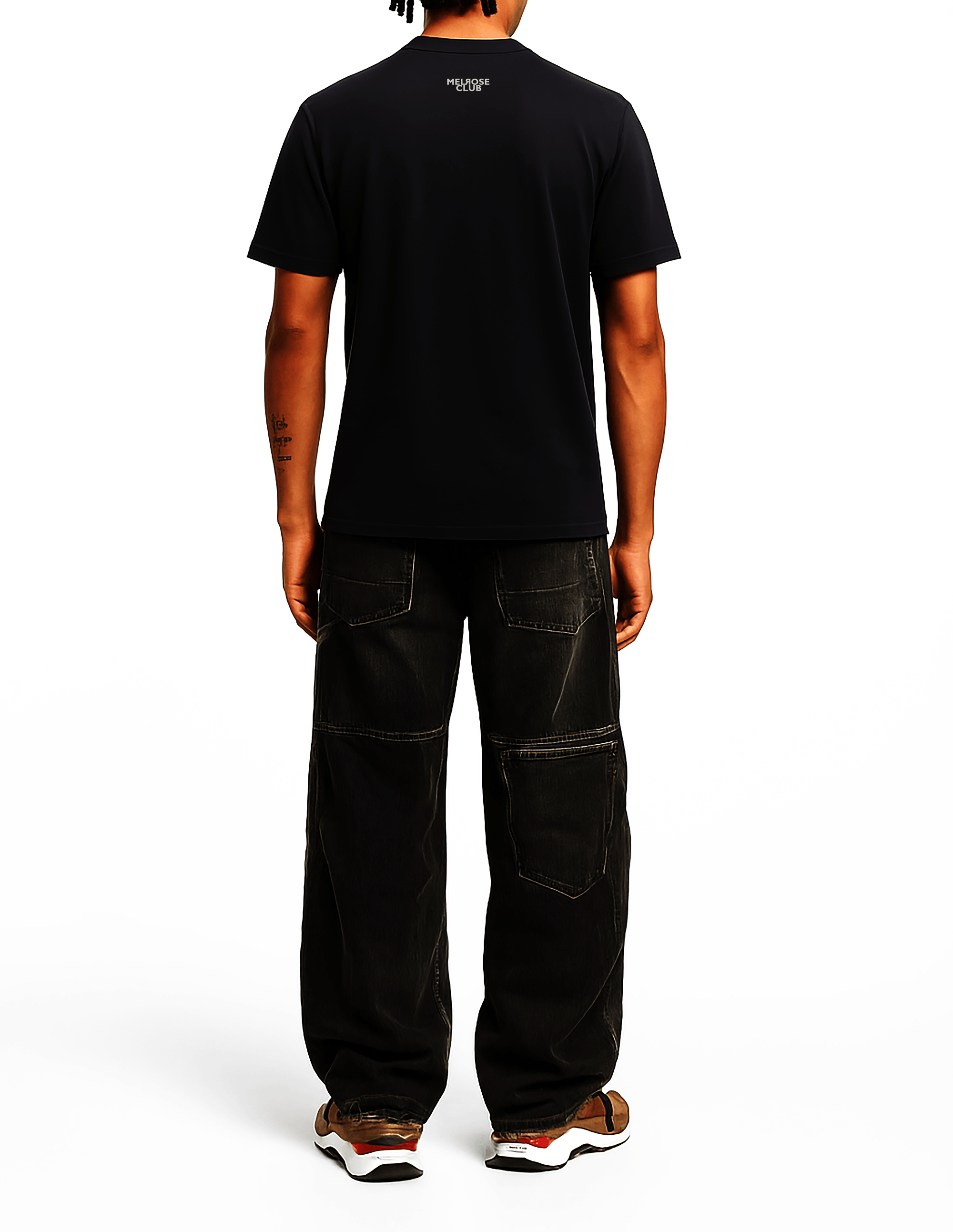 Back view of a man wearing a black Melrose Club cloud pop t-shirt paired with black pants and sneakers