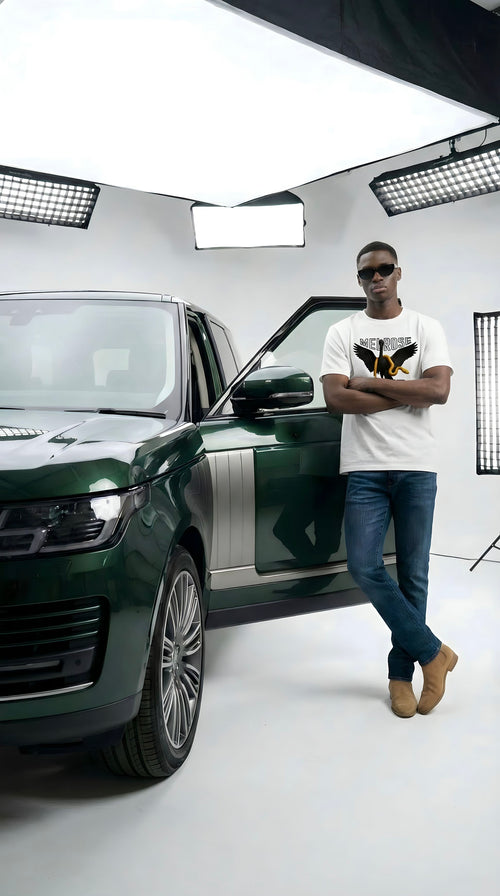 Man standing next to a green Range Rover in a studio setting